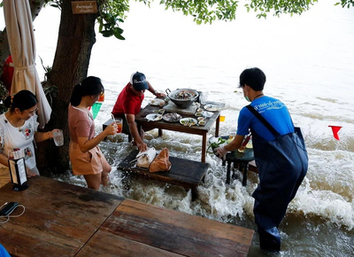 Nhà hàng ngập trong nước, khách hàng vẫn ung dung ngồi ăn mặc cho đàn cá rỉa chân
