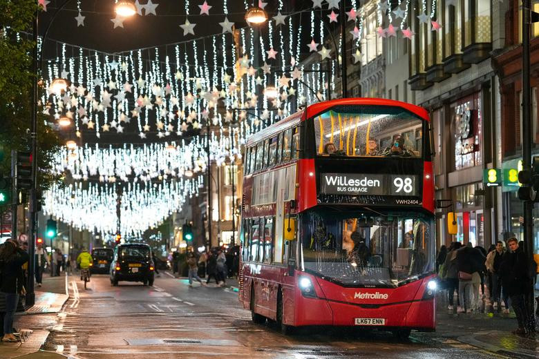 Người dân đi xe buýt trên Phố Oxford được chiếu sáng bằng đèn Giáng sinh ở London, Anh.