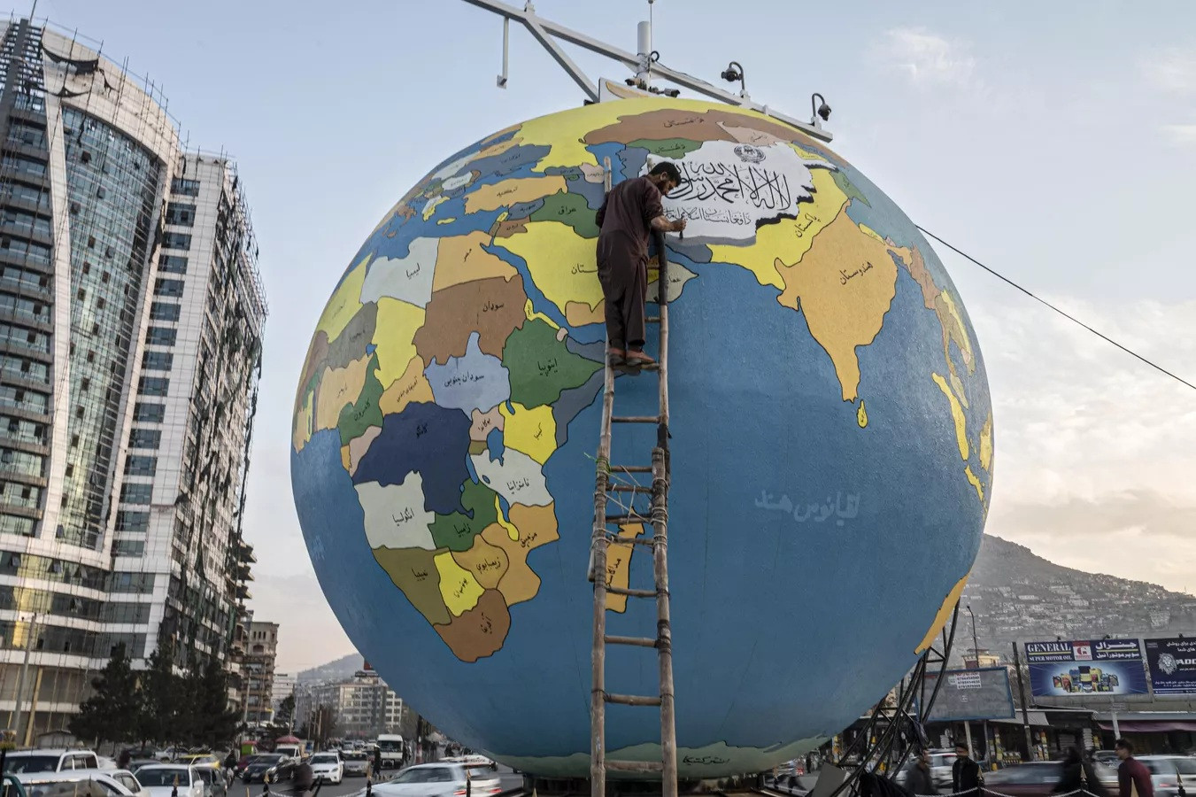 Họa sĩ vẽ những nét cuối cùng trên một quả cầu lớn chứa hành tinh Trái đất ở Kabul, Afghanistan.