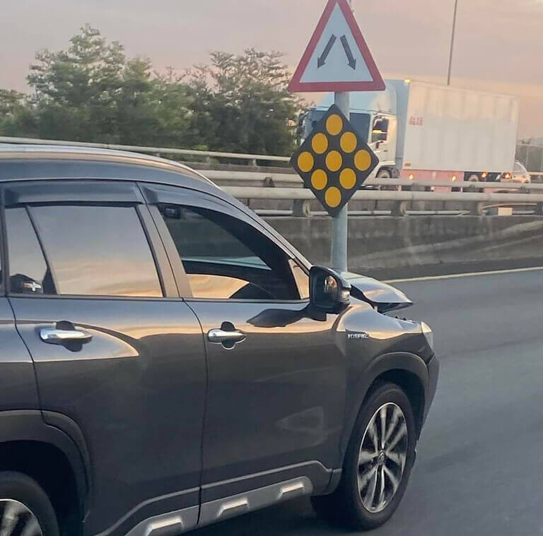 Ô tô chạy bon bon trên đường, mang theo cả cột biển báo giao thông sau cú đâm