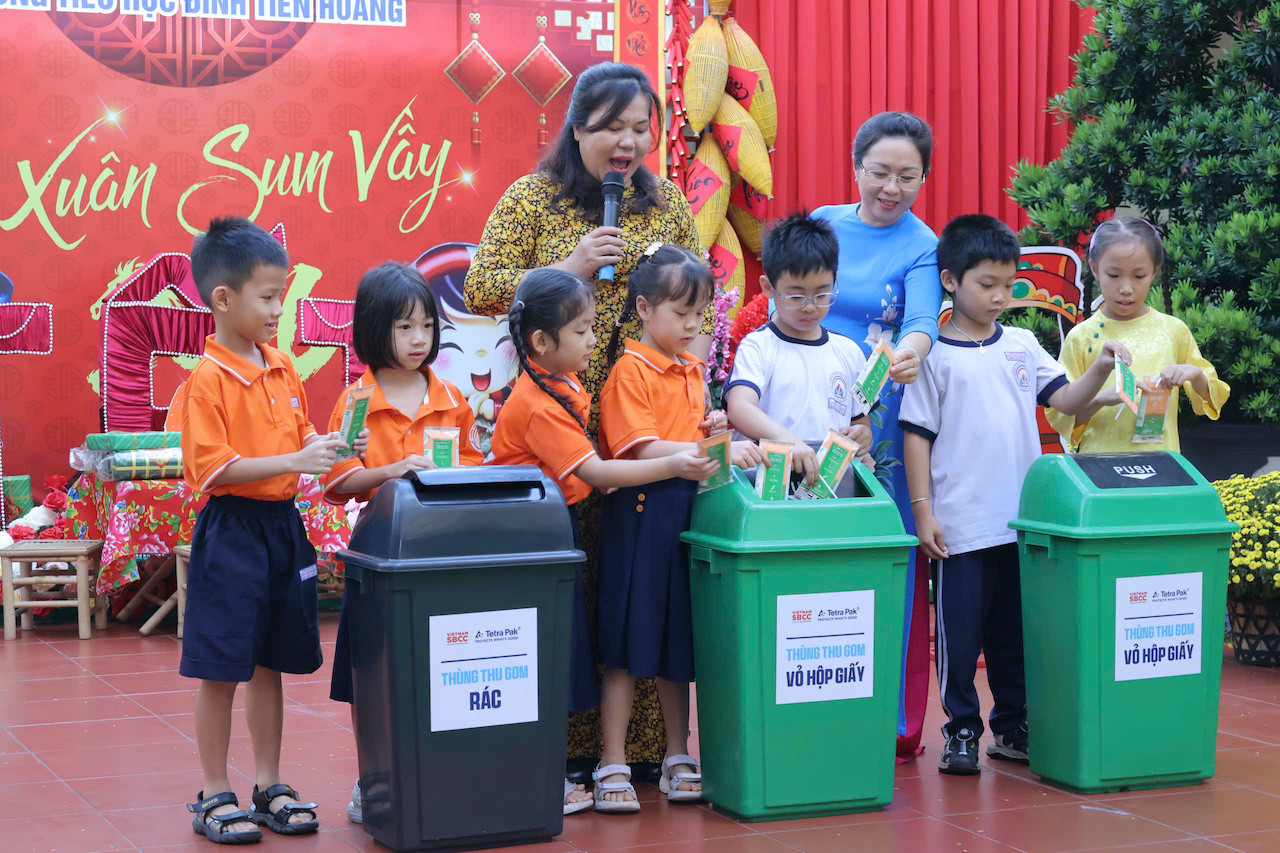 Học sinh đang được hướng dẫn phân loại vỏ hộp sữa tại trường Đinh Tiên Hoàng.jpg