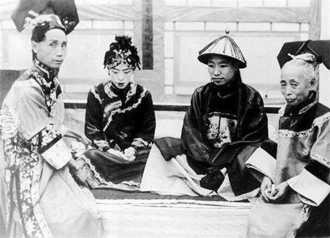 Khi nghi lễ hoàn tất, đôi tân lang và tân nương ngồi e lệ bên nhau trên sập gỗ, còn người hầu đứng cạnh phục vụ bữa tiệc. (Ảnh: Sohu)