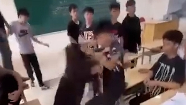 Nhiều nam sinh hò hét cổ vũ nam sinh và nữ sinh đánh nhau. (Ảnh cắt từ clip)