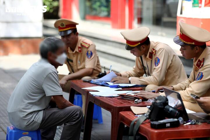 Tổ công tác lập biên bản với tài xế vi phạm nồng độ cồn.