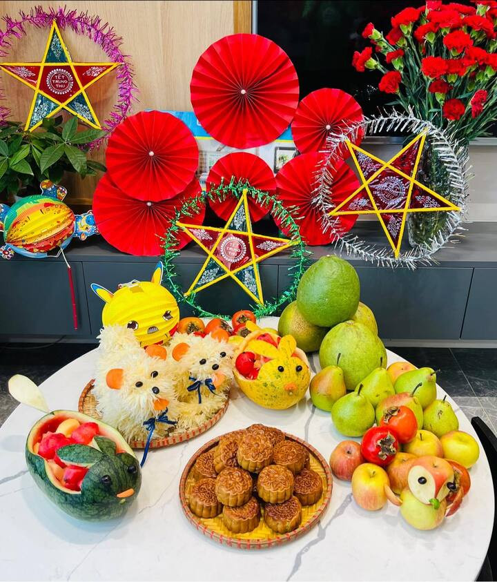 Mâm cỗ trăng rằm được bày biện đơn giản tại nhà, mang sắc thái sum vầy, với trái cây tươi, bánh trung thu và hoa, tượng trưng cho sự đủ đầy. (Ảnh: Hòa Bùi)