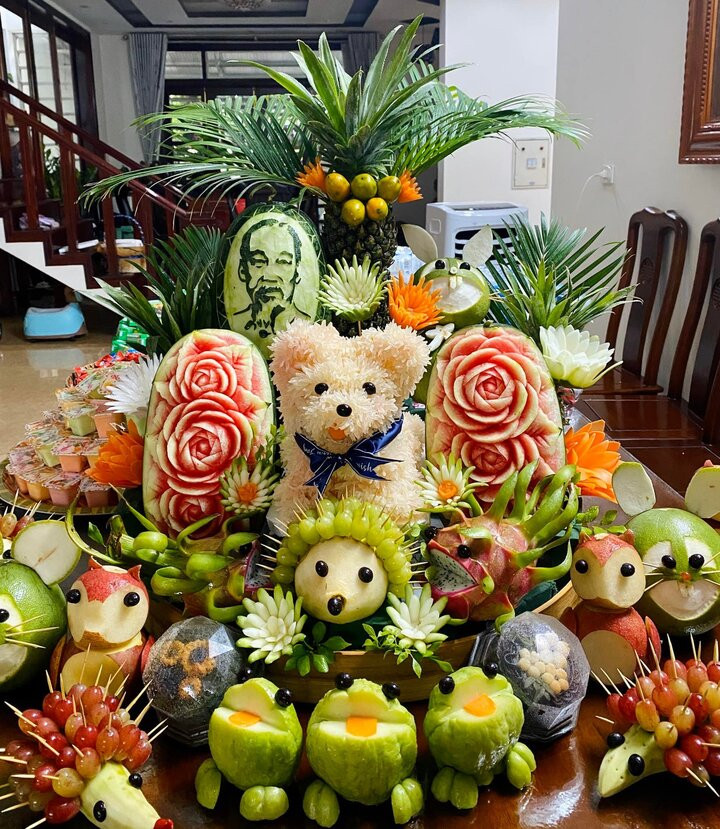 Mâm cỗ Trung thu trở nên sống động hơn nhờ những loại trái cây được cắt tỉa cầu kỳ, khéo léo tạo thành đủ hình thù ngộ nghĩnh như chú chó bằng quả bưởi, chú gấu đáng yêu kết bằng chùm nho. Sự sáng tạo ấy không chỉ khiến mâm cỗ thêm rực rỡ, bắt mắt mà còn mang lại niềm vui, sự háo hức cho các em nhỏ trong đêm trăng rằm. (Ảnh: Phạm Thu Huyền)