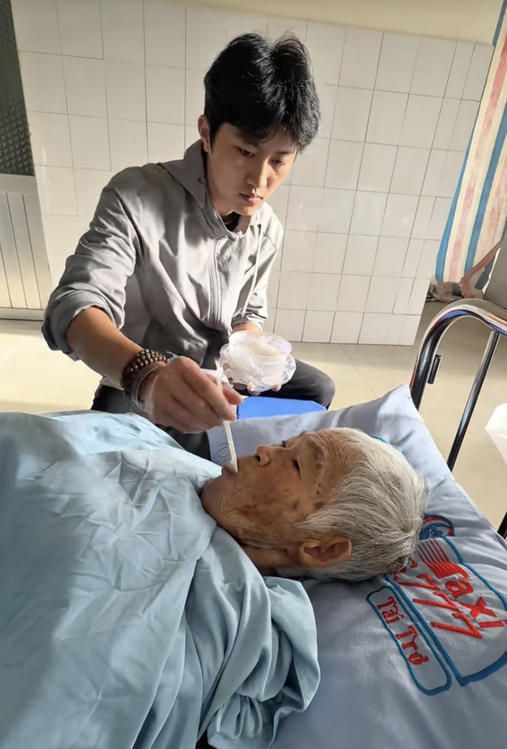 Nam bón cho bà ăn từng thìa cháo.