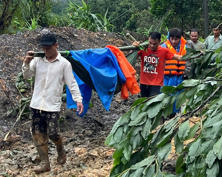 Lực lượng chức năng và người dân khiêng 5 nạn nhân đi cấp cứu.