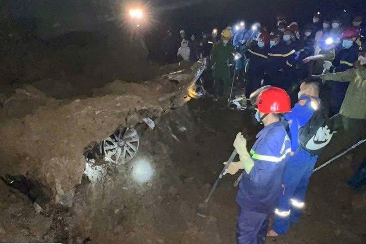 Xe bán tải bị vùi lấp trong đất đá bẹp dúm, biến dạng hoàn toàn. (Ảnh: Công an xã Minh Lương)