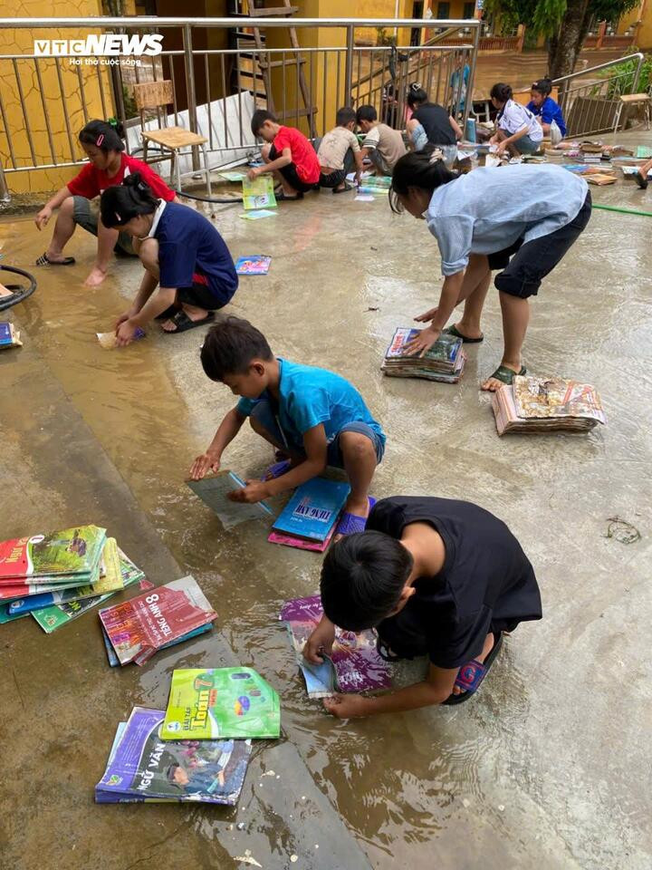 Học sinh rửa sạch sách vở bị dính bùn đất, đem phơi khô tái sử dụng