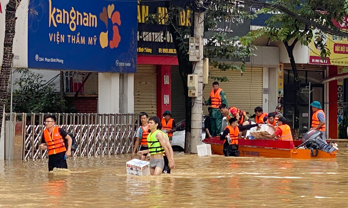 Nhiều đoàn thiện nguyện dầm mình trong nước để hỗ trợ người dân. .jpg