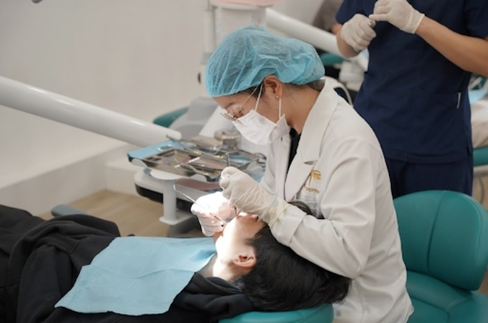 Bác sĩ Vi Na thăm khám cho một bệnh nhân gặp vấn đề về răng miệng. (Ảnh: Loan Bùi)