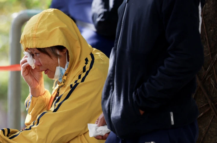 Một người phụ nữ đang chờ nhận diện thi thể người thân. (Ảnh: Reuters)