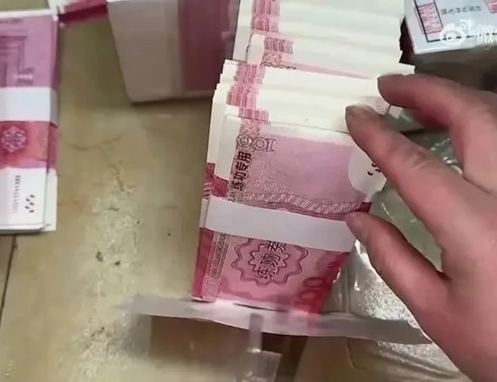 Chen khéo léo đặt những tờ tiền thật lên trên và dưới một đống tiền giấy giả. (Ảnh: WeCha)