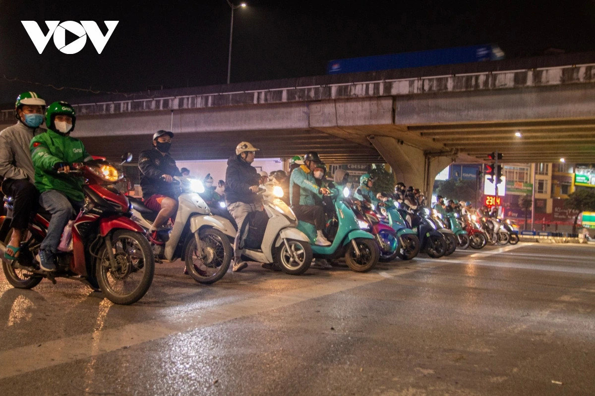 Dem ha noi, duong vang nhung xe co van deu tam tap truoc vach ke dung den do hinh anh 3
