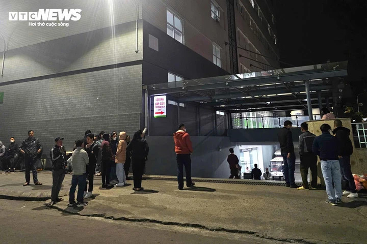 Người thân các nạn nhân đứng chờ đợi thông tin từ khu cấp cứu tại Bệnh viện Việt Đức trong đêm, sau vụ lật xe khách nghiêm trọng.