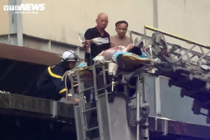 Lực lượng chức năng dùng xe thang đưa nạn nhân khỏi khu vực mái tôn để đi cấp cứu. (Ảnh: Minh Đức)