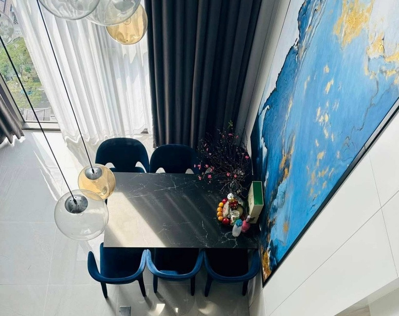 Khu vực bàn ăn được đặt tại khu có cửa sổ lớn và được bài trí hoa đào, mâm quả và khung tranh cỡ lớn.