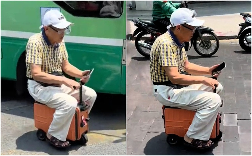 Người đàn ông cưỡi vali chạy ngoài đường. (Ảnh: SGGP)