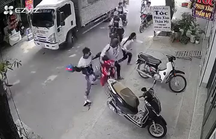 Nam sinh bị bạn cầm mũ bảo hiểm đập liên tiếp vào đầu. (Ảnh cắt từ clip)