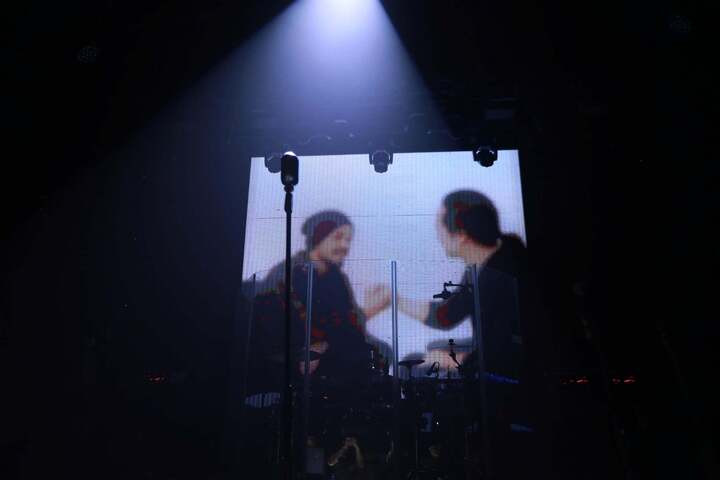 Nhạc sĩ Trần Lập xuất hiện trên màn hình với sự hỗ trợ của công nghệ, cùng các thành viên ban nhạc vui vẻ chuyện trò.