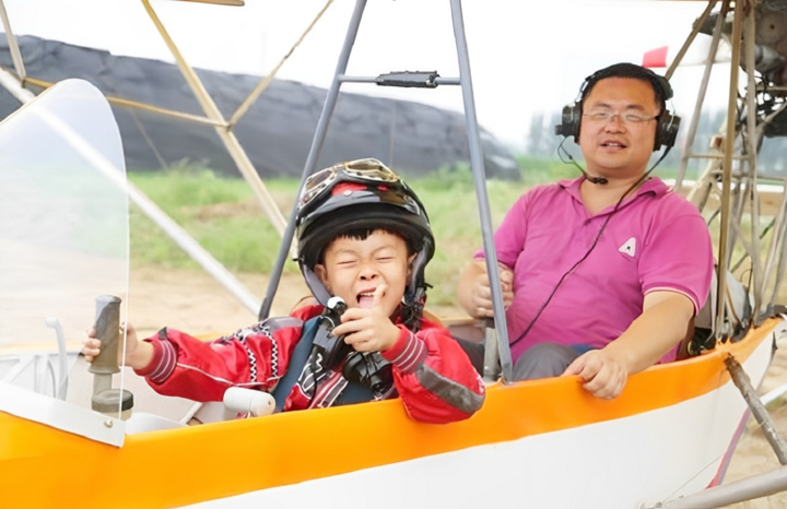 Hà Nghi Đức cùng cha trong buồng lái, thời điểm cậu bé 5 tuổi lập kỷ lục phi công trẻ nhất thế giới. (Ảnh: Baidu)