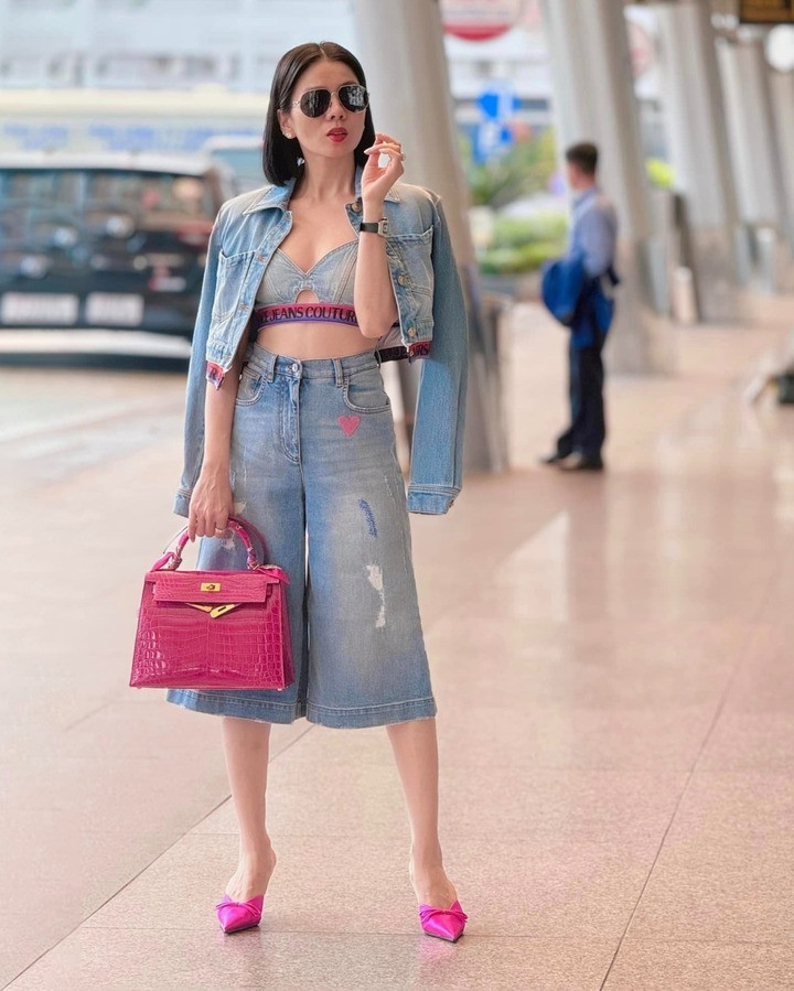 Lệ Quyên diện cả bộ trang phục denim của Versace với loạt phụ kiện tông hồng gồm túi Kelly và dép cao gót. Dù mang trên mình