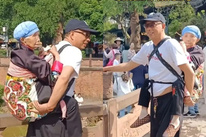 Người đàn ông hơn 50 tuổi địu mẹ già 92 tuổi trên lưng. Ảnh: Sohu.