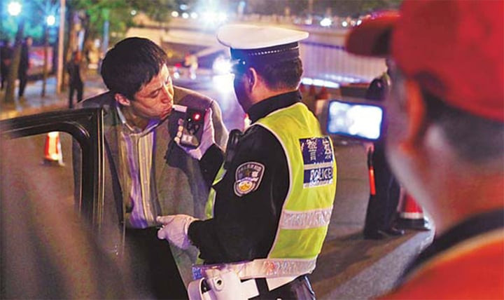 Cảnh sát giao thông Trung Quốc đo nồng độ cồn của tài xế. (Ảnh: China Daily)