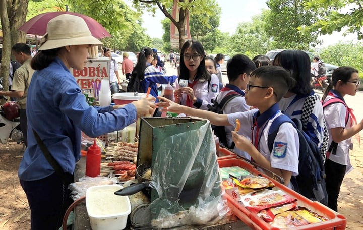 Những quầy hàng ăn vặt gần trường luôn thu hút rất nhiều học sinh. (Ảnh: Tuổi trẻ Thủ đô)
