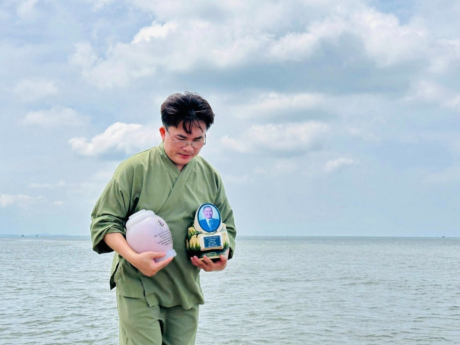 Hình ảnh MC Đại Nghĩa ôm hai bình tro cốt khiến ai cũng xót xa