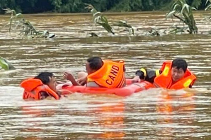 Cán bộ chiến sĩ ngâm mình dưới nước đưa người già, trẻ nhỏ và tài sản ra khỏi khu vực ngập. (Ảnh: Công an tỉnh Lai Châu)