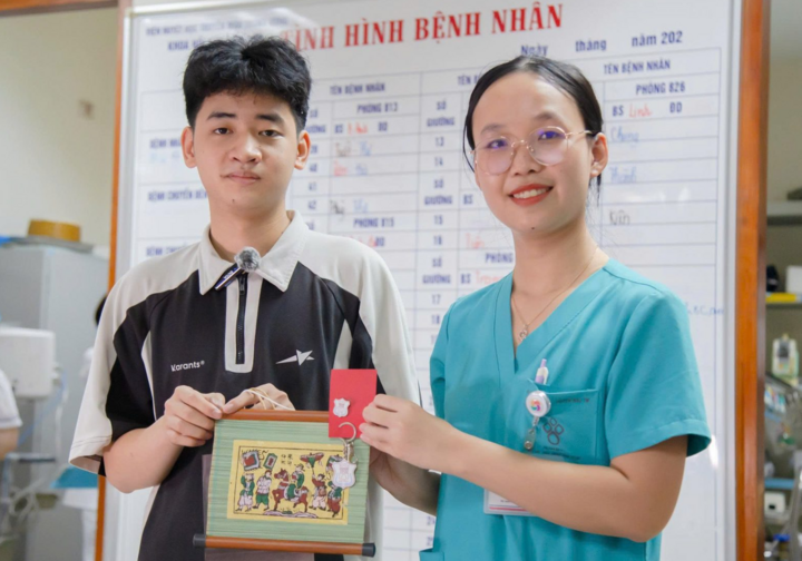 ThS. Phan Thị Thuỳ Trang tặng Bách bức tranh Vinh quy bái tổ để chúc mừng thành quả học tập. (Ảnh: Trần Chiến)