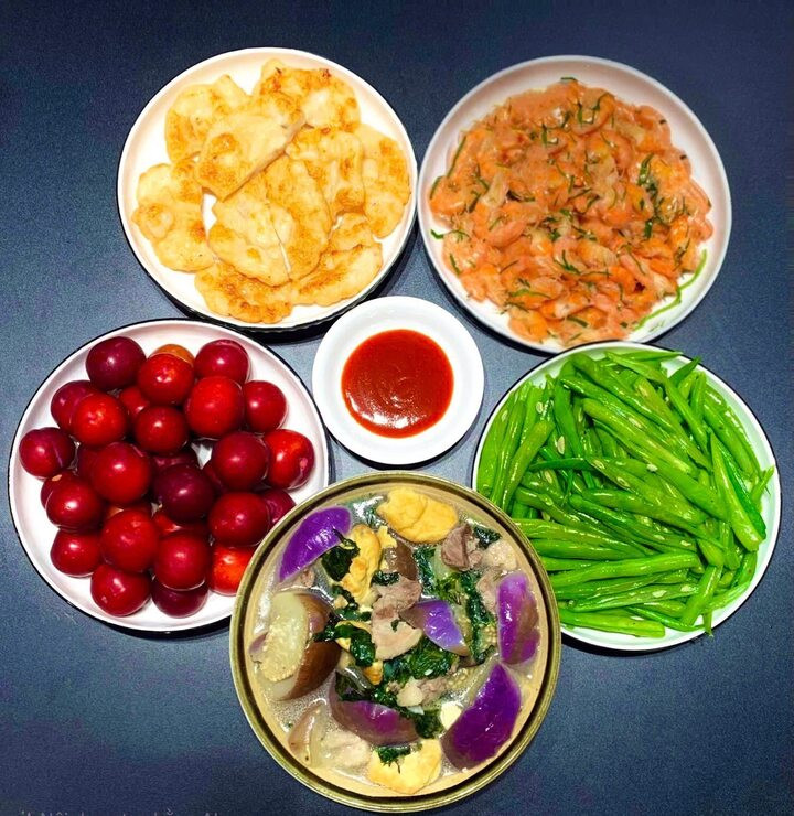 Mâm cơm hấp dẫn với món tôm rang, chả mực, cà bung đậu, đỗ xào và tráng miệng với quả mận.