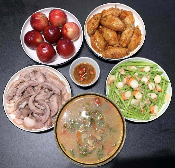 Bữa ăn này có cánh gà chiên mắm, má lợn luộc, rau xào, canh chua và tráng miệng bằng quả đào.