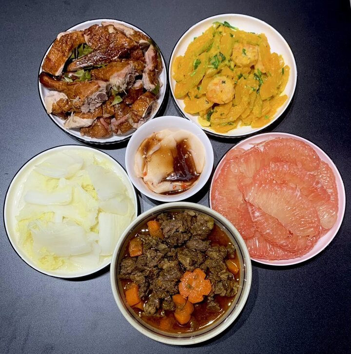 Mâm cơm này có vịt quay, bò sốt tiêu, bí ngô xào, cải thảo luộc và tráng miệng bằng bưởi.