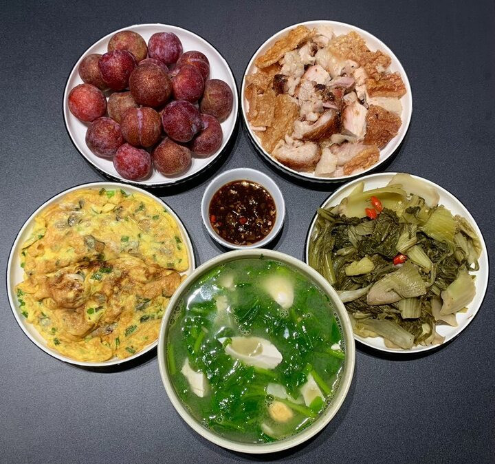 Thực đơn gồm món thịt lợn chiên ăn kèm dưa chua, trứng rán hàu, canh mồng tơi trứng muối và tráng miệng với mận.