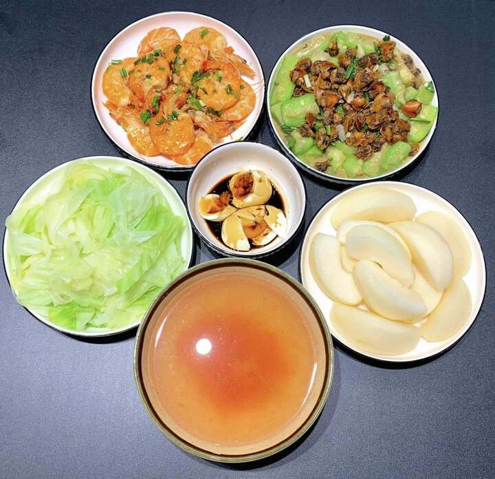 Món chính là tôm rim, cồi sò gạo xào mướp, rau luộc, tráng miệng bằng quả lê.