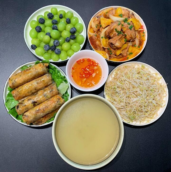 Cải thiện bữa cơm với món nem rán, sườn rim dứa, giá đỗ luộc, tráng miệng bằng nho.