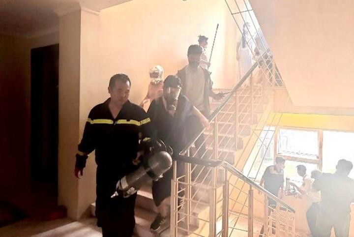 Lực lượng chức năng tổ chức hướng dẫn thoát nạn và giải cứu 2 người dân bị ảnh hưởng bởi khói.