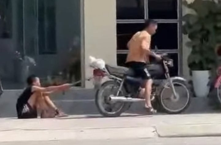 Cháu bé bị xích chân, trói tay, kéo lê dọc đường. (Ảnh cắt từ clip chia sẻ trên MXH)