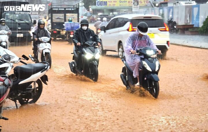 Ô tô, xe máy di chuyển khó khăn trong làn nước ngập.