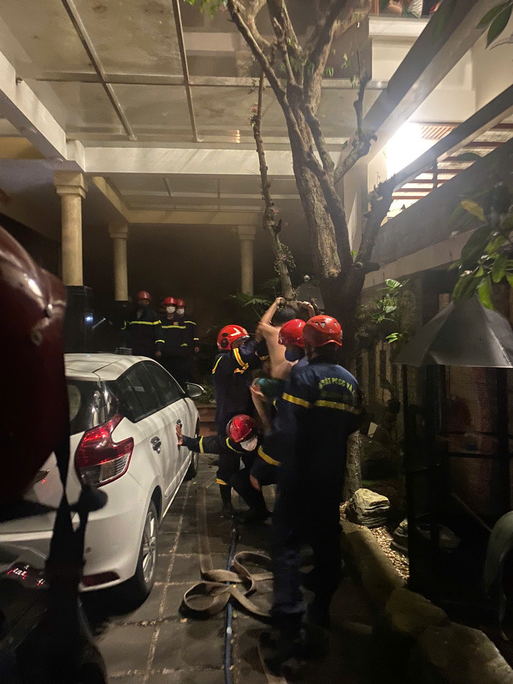 Lực lượng chức năng cứu 5 người khỏi đám cháy. (Ảnh: Đ.N)