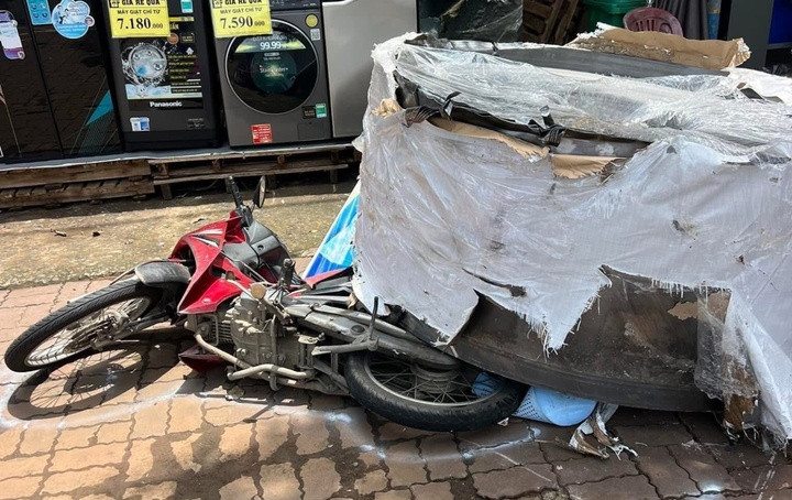 Cuộn thép hàng chục tấn rơi xuống đường đè bẹp xe máy. (Ảnh: Lạc Sơn)