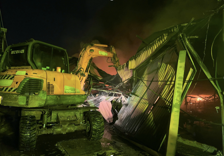 Cảnh sát huy động máy xúc phá dỡ cấu kiện sụp đổ, mở lối cho lực lượng PCCC tiếp cận vào trong.