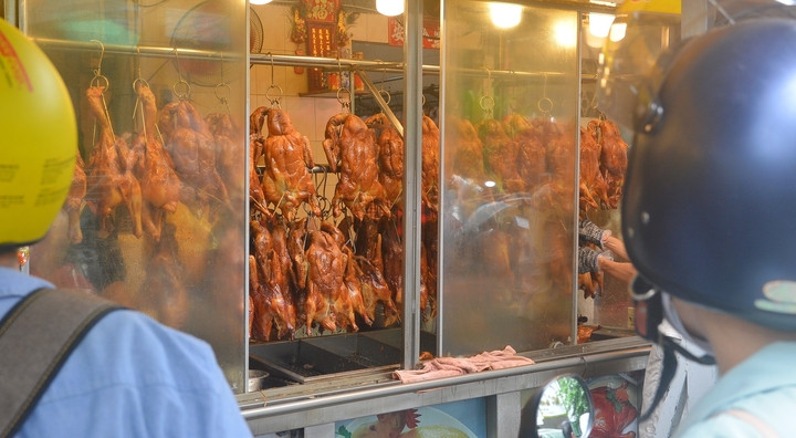 Người dân chờ lấy vịt quay nóng hổi tại các cửa tiệm. (Ảnh: Đại Việt)