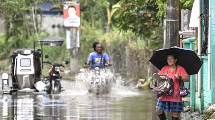 Người dân lội qua khu vực ngập lụt ở Bulacan, Philippines. (Ảnh: Getty)