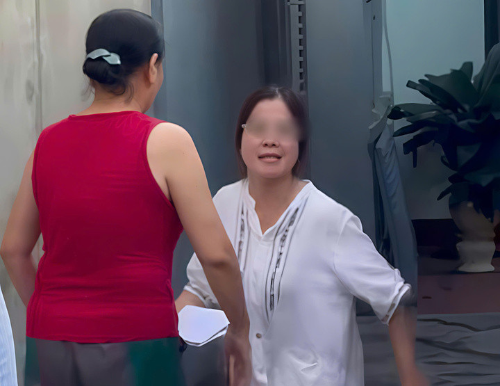 Người phụ nữ mặc áo trắng đỗ ô tô chắn ngang đường trong một con ngõ nhỏ trên đường Nguyễn Du, thuộc phường Đông Kinh, tỉnh Lạng Sơn. (Ảnh cắt từ clip).