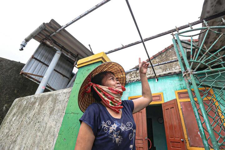 Bà Trần Thị Hằng (Hà Tĩnh) đứng lặng trước căn nhà mới xây, mái gần như bị tốc hết, trần rơi xuống, nước ngấm loang lổ khắp nơi