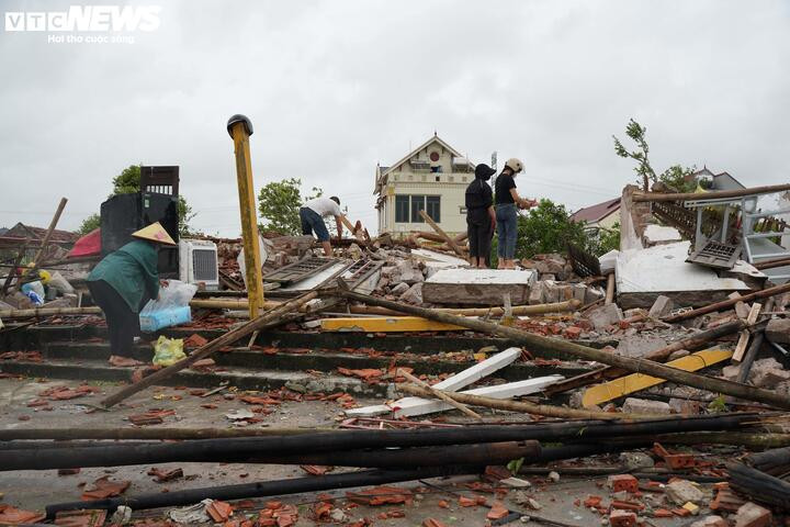 Hàng xóm giúp chị Sinh tìm lại các vật dụng trong đống đổ nát.